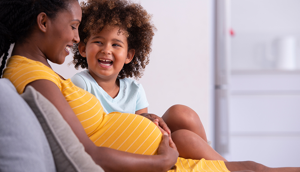 Happy pregnant African-American woman with her toddler