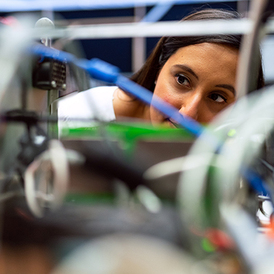 Woman peering into complex device